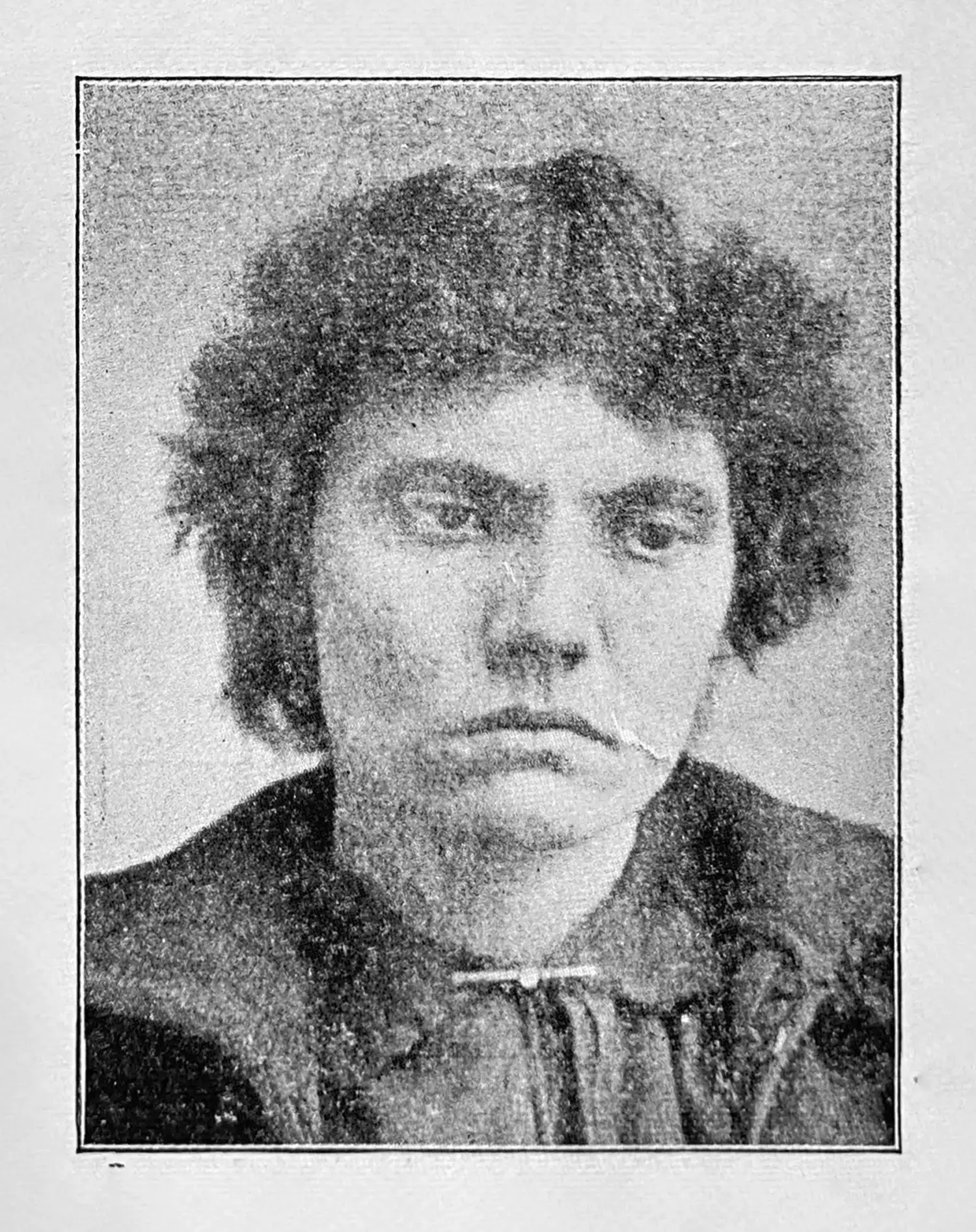 A woman with wavy, short hair. She is unsmiling and has a perhaps defiant or contemplative expression.